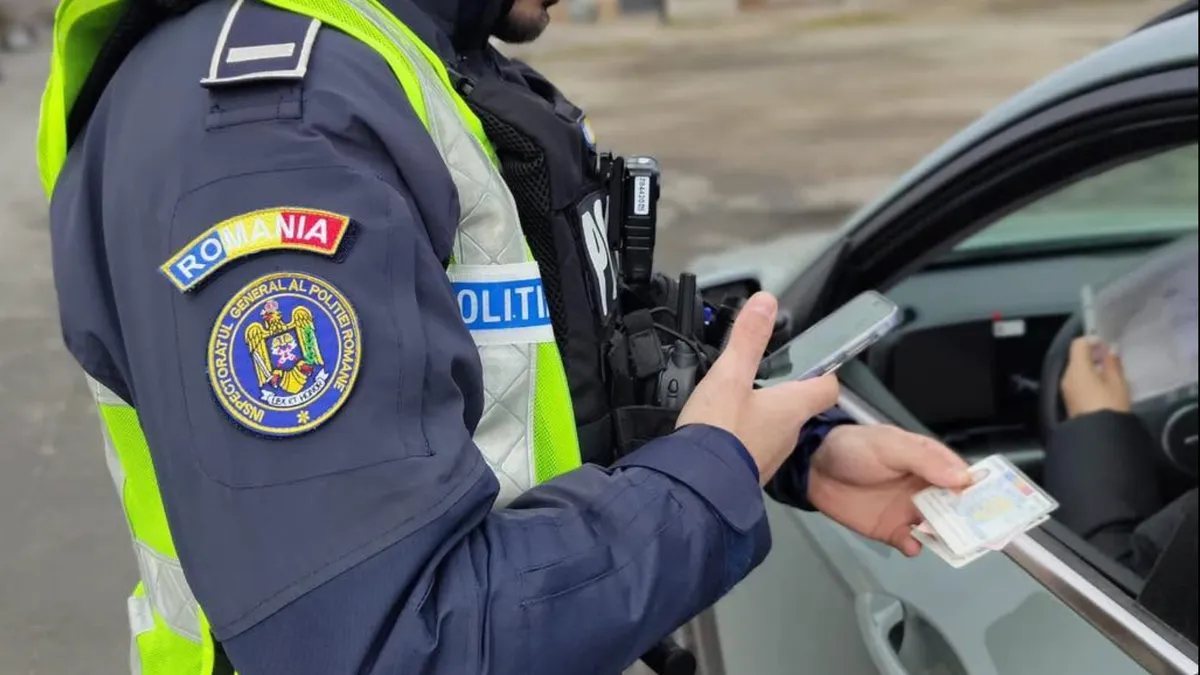 Șofer oprit în trafic de un polițist pentru verificarea actelor