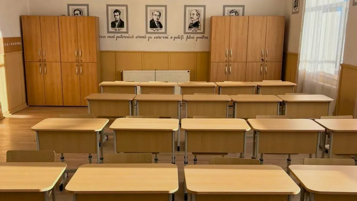 sala de clasă de școală cu bănci și portrete de scriitori pe un perete