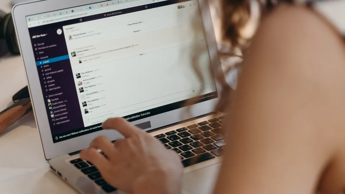 O tânără tastează la un laptop mesaje pe platformă online