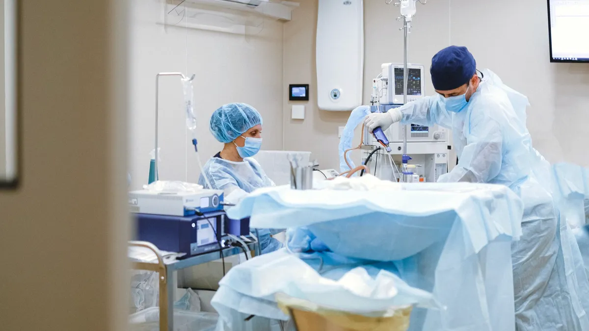 doi medici execută proceduri într-un salon de spital