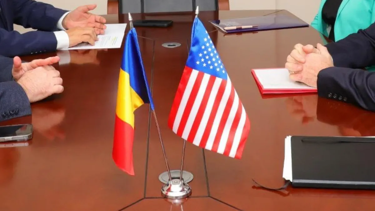 Steagul României și steagul SUA alăturate, pe o masă de ședință