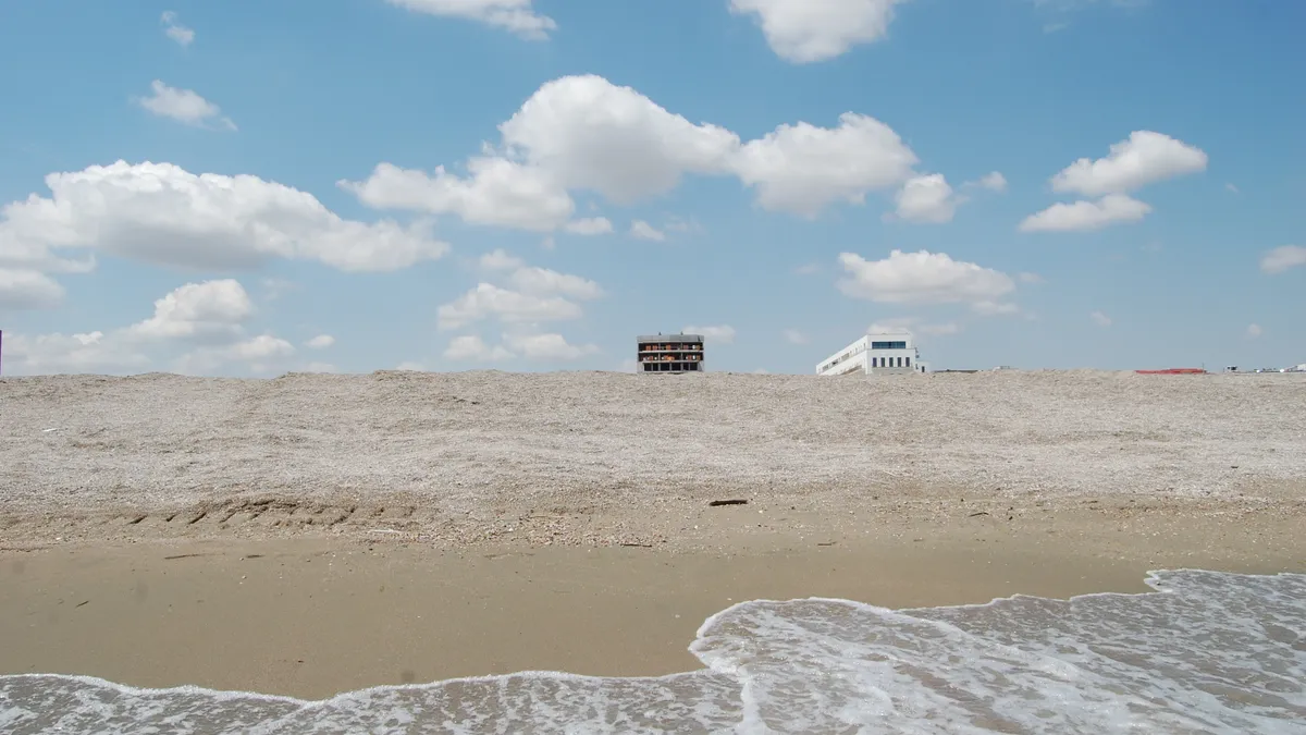 Două clădiri abia se văd de după coama plajei la Mamaia