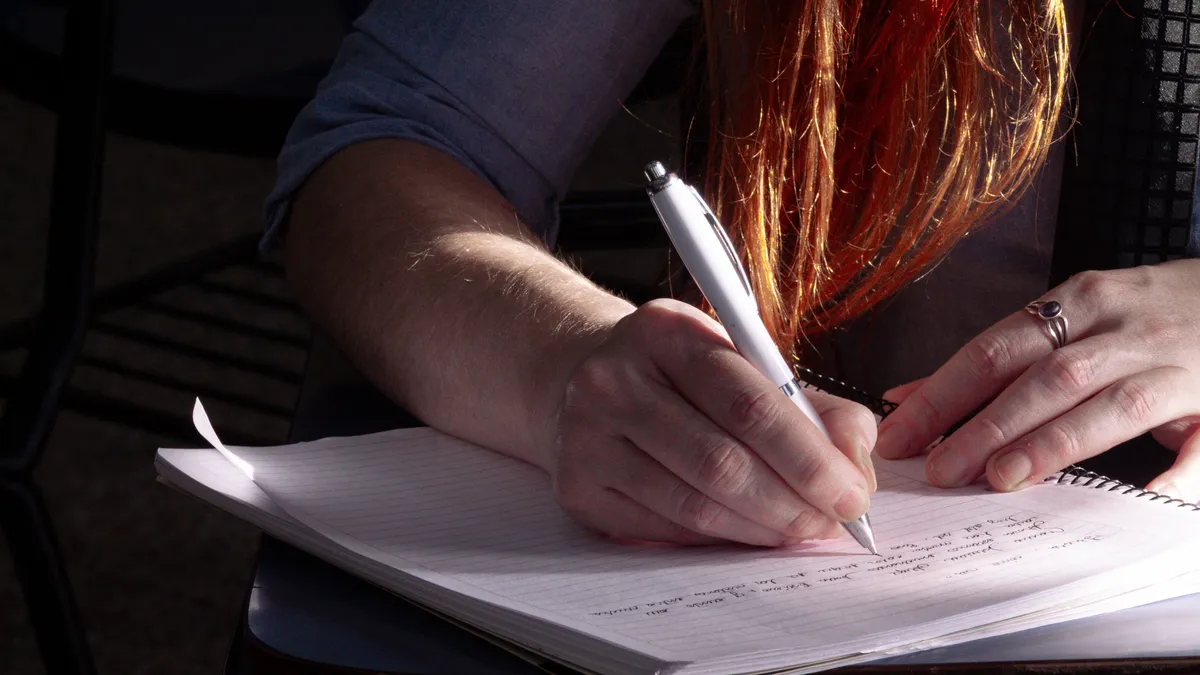 Persoană care completează o foaie în timpul unui examen