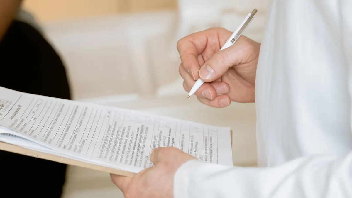 Medic care completează un formular