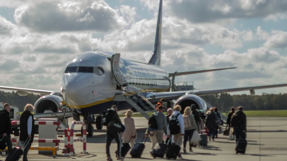 pasageri pe pistă îmbarcându-se într-un avion Ryanair