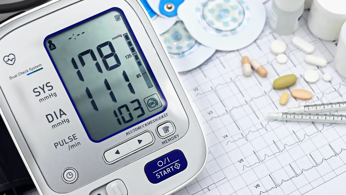 tensiometru, instrumentar medical, un grafic EKG și pastile