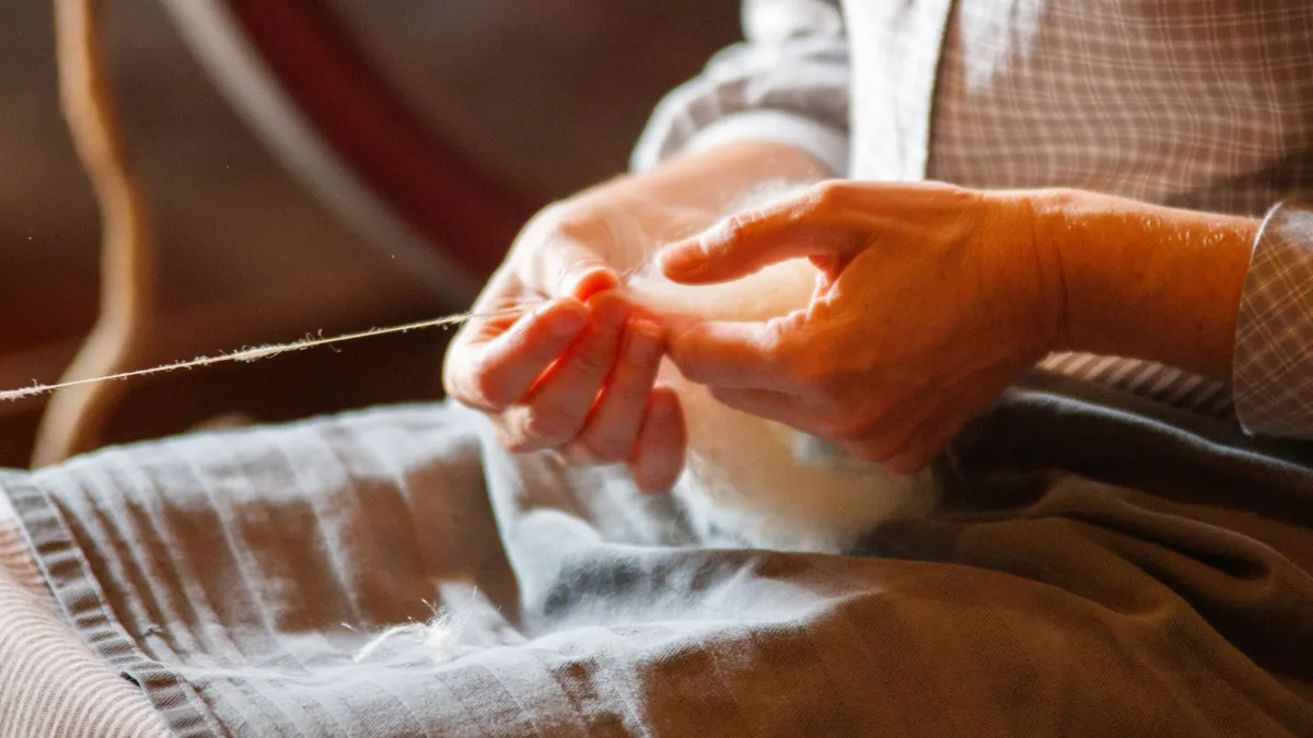 Pensionară care lucrează manual cu fibre textile.