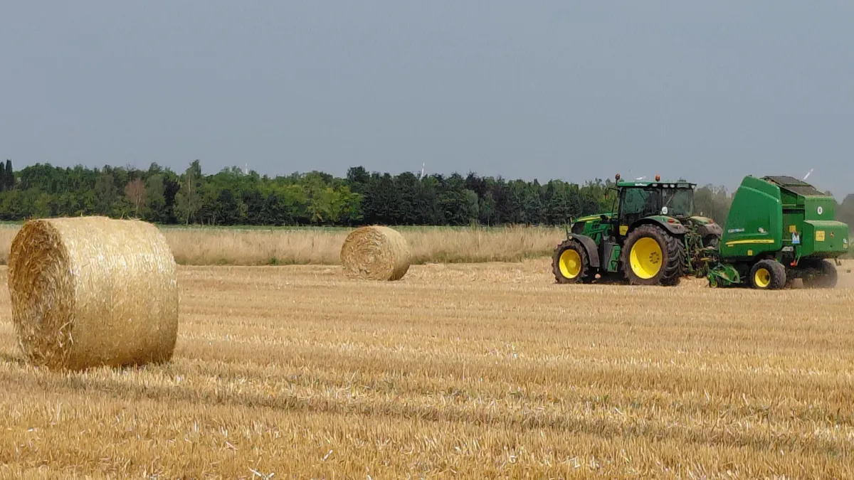 tractor pe un câmp de pe care s-au recoltat cereale