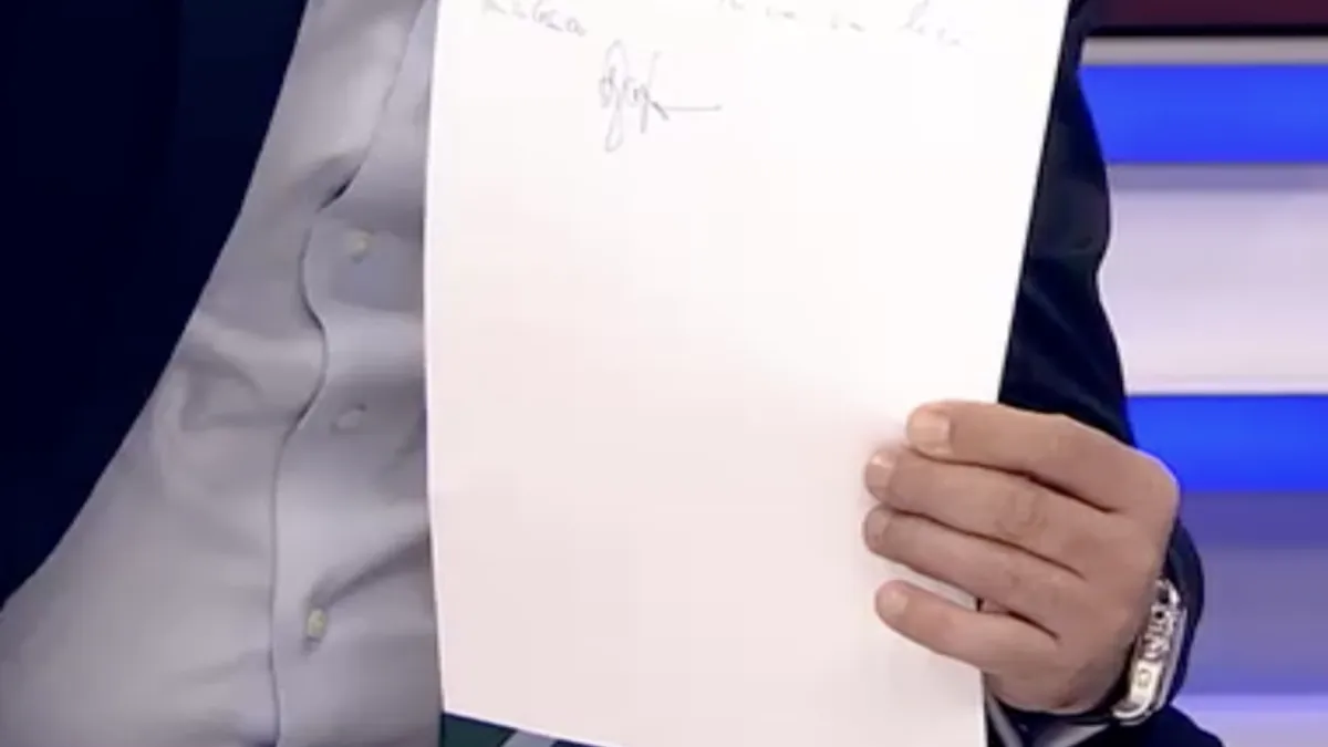Senatorul Zamfir prezentând hârtia semnată în care declară că nu va vota guvernul Niculescu