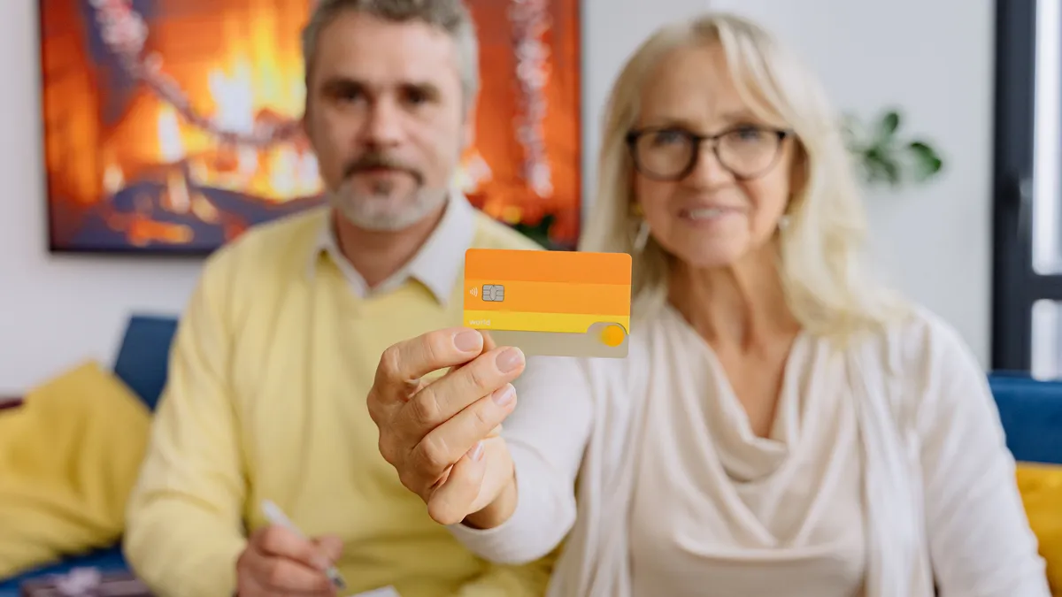 Cuplu de pensionari folosind un card bancar.