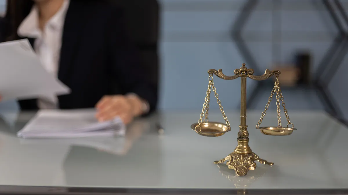 Simbolul justiției, o balanță, pe biroul cuiva care verifică acte.