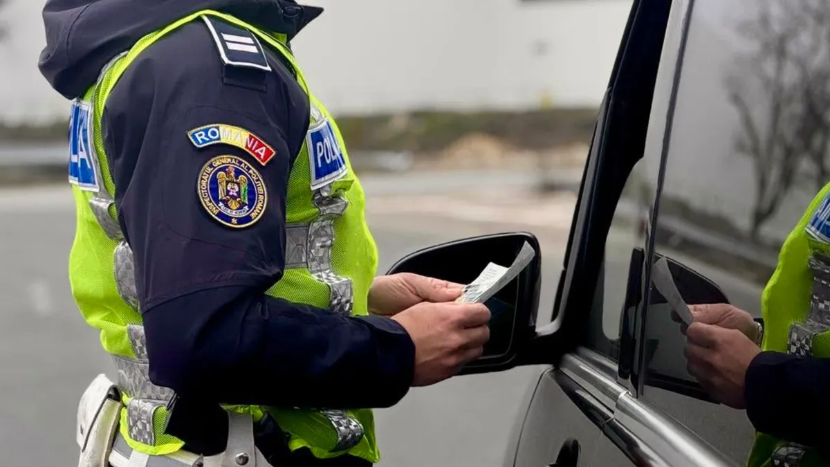 Polițist verificând documente în timpul unui control rutier