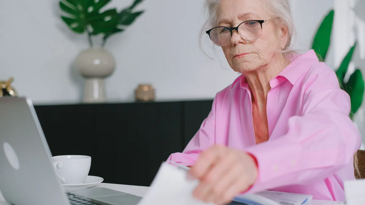 Pensionară care verifică mai multe documente