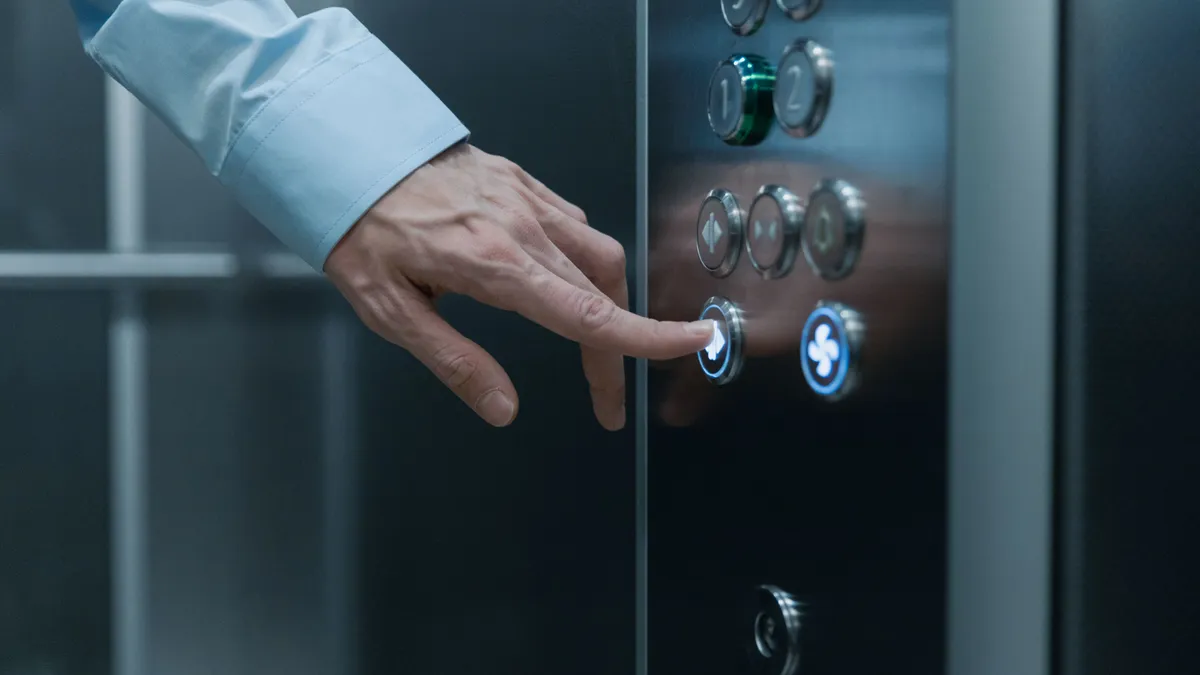 Persoană care apasă butonul unui lift