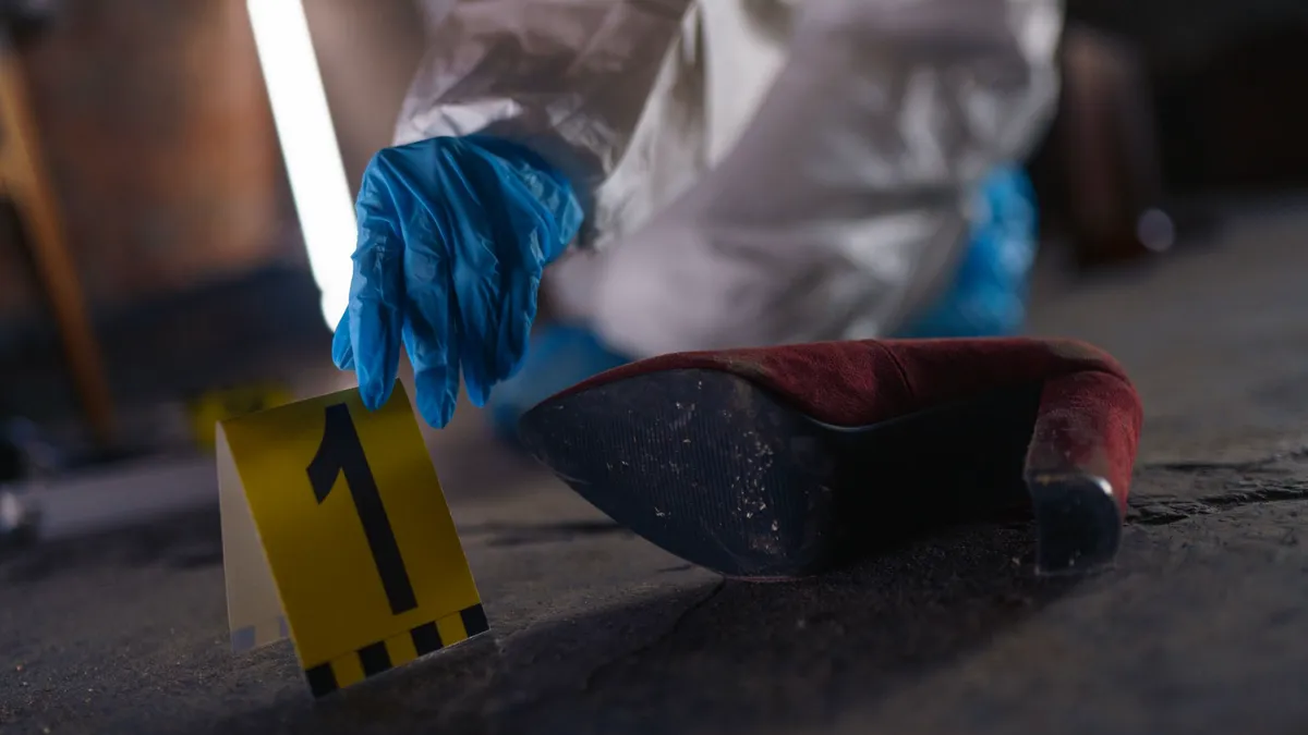 Scenă a crimei cu pantof de femeie și costum de criminalist