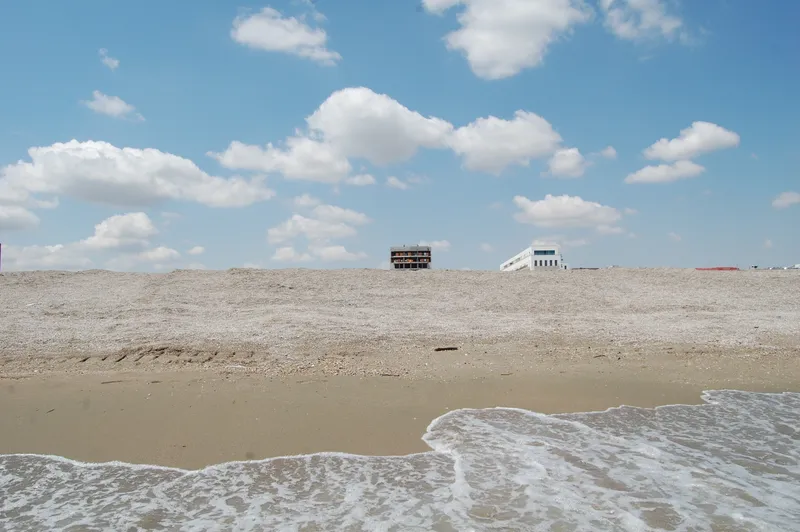 Două clădiri abia se văd de după coama plajei la Mamaia