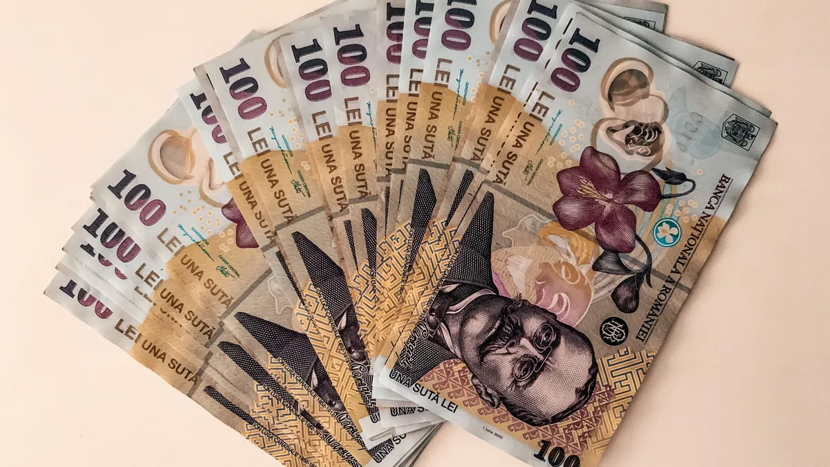 Bancnote românești de 100 de lei, dispuse în evantai.