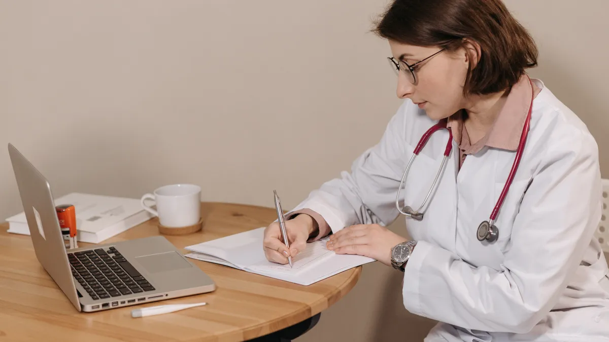 Medic care completează documente pe hârtie