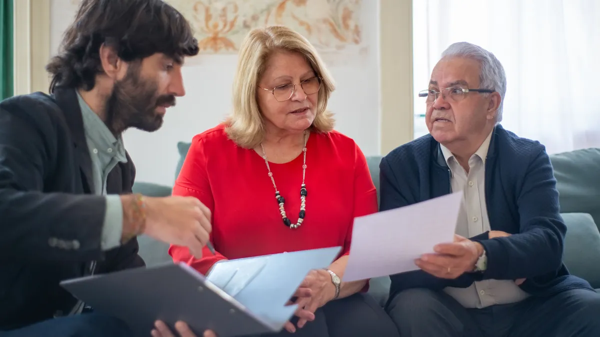 Pensionari care verifică mai multe acte și documente.