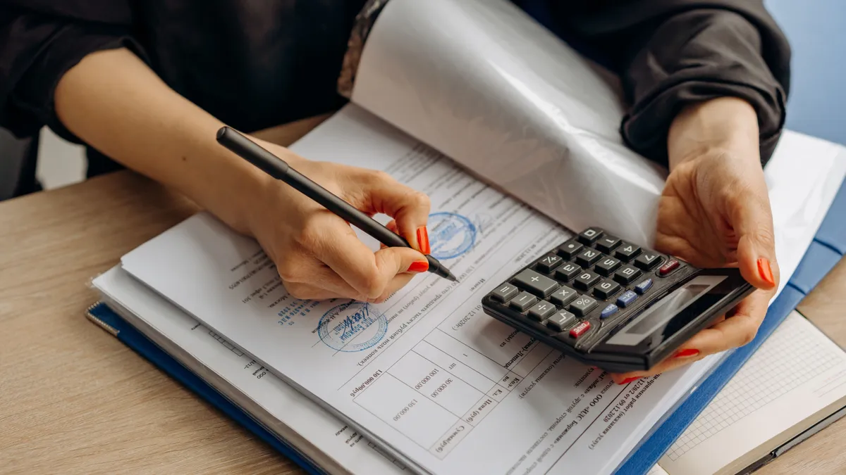 Persoană care verifică documente și face calcule